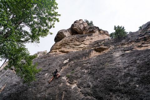 Climber tackling the rugged terrain of Story, Wyoming's rocky landscape.