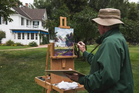 An artist painting at the Brinton Ranch house, a top thing to do in Sheridan, Wyoming.