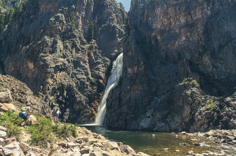 Majestic Porcupine Falls cascades into a tranquil pool, framed by steep cliffs, a stunning hiking trails near Sheridan.