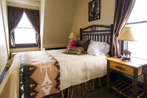 Cozy bedroom at Historic Sheridan Inn, reflecting the Western elegance of yesteryears.
