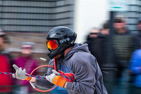 Close-up of a focused skijoring skier in Sheridan, WY, gripping the tow rope and ready for the thrilling race ahead.