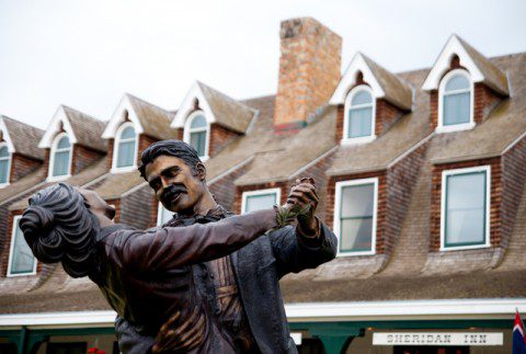 Statue of a man and woman dancing in front of the Historic Sheridan Inn.