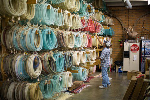 Inside King's Saddlery in Sheridan, a shopper examines rows of colorful lariats, a must-visit top thing to do, a shop for rodeo enthusiasts.