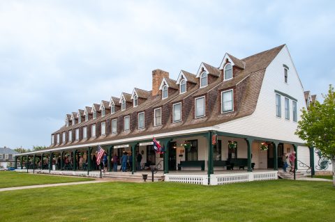 Historic Sheridan Inn's charming exterior with its iconic wraparound porch and dormer windows.
