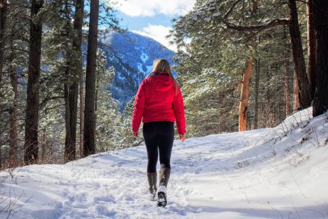 A hiker traverses the snowy path of South Piney Creek, a popular destination among hiking trails near Sheridan, WY.